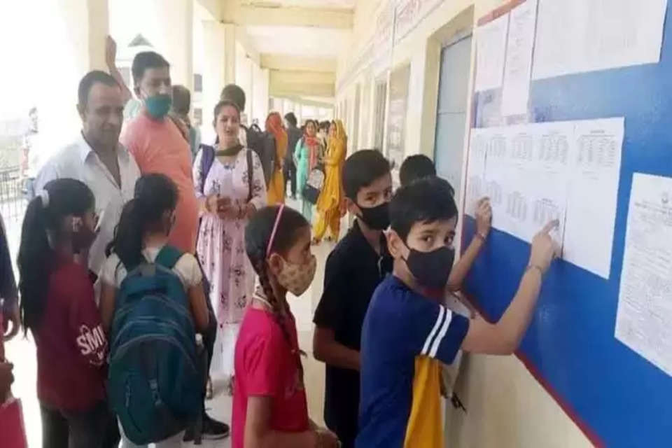 जेएनवी प्रवेश परीक्षा के लिए बाल स्कूल हमीरपुर में लगे सिटिंग प्लान को देखते बच्चे