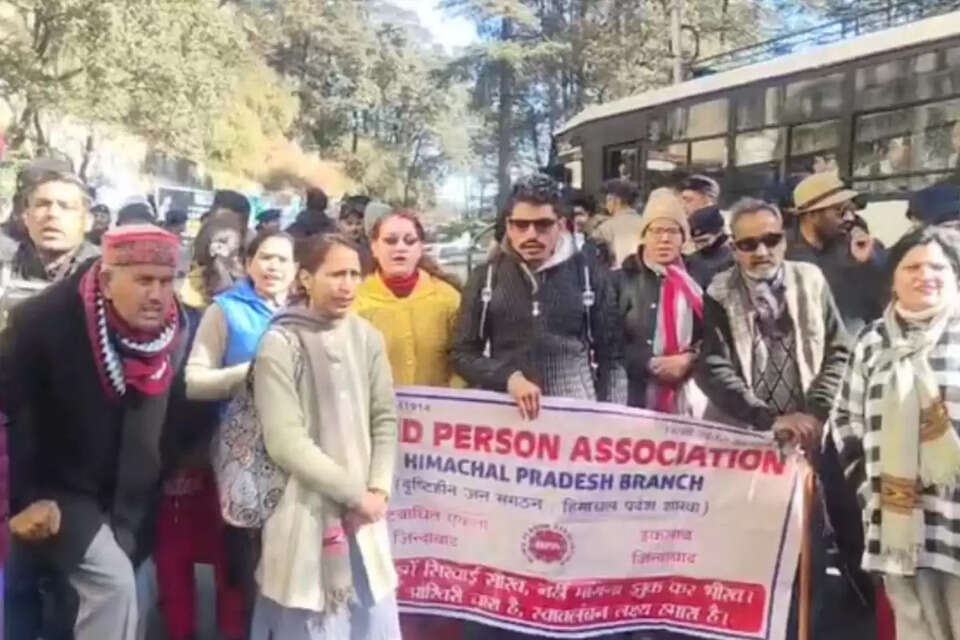 हिमाचल प्रदेश की राजधानी शिमला में अपनी मांगों को लेकर संघर्षरत दिव्यांगों का धैर्य सोमवार को जवाब दे गया। सचिवालय के बाहर पिछले 70 दिनों से धरने पर बैठे दिव्यांगों ने सोमवार सुबह 10 बजे कार्ट रोड पर 'चक्का जाम' कर जोरदार प्रदर्शन किया। इस विरोध प्रदर्शन के कारण शहर की मुख्य लाइफलाइन कही जाने वाली सड़कों पर वाहनों की आवाजाही पूरी तरह ठप हो गई, जिससे यातायात व्यवस्था चरमरा गई।    दृष्टिहीन जनसंगठन के जिला प्रभारी राजेश ठाकुर ने बताया कि दिव्यांगों का यह आंदोलन महज कुछ दिनों का नहीं है। कालीबाड़ी मंदिर के पास धरने पर बैठे हुए इन्हें आज 804 दिन पूरे हो चुके हैं।    शिमला दिव्यांग प्रदर्शन, सचिवालय चक्का जाम, दृष्टिबाधित संगठन हिमाचल, दिव्यांग पेंशन मांग, शिमला समाचार   Shimla Disability Protest, Secretariat Road Block, Himachal Specially Abled Demands, HP Govt Backlog Recruitment, Shimla Traffic Jam News.
